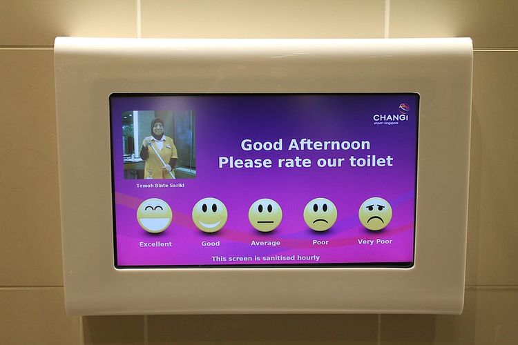 A feedback screen in a toilet reading "Good afternoon, please rate our toilet" with options from 'excellent' to 'very poor'.